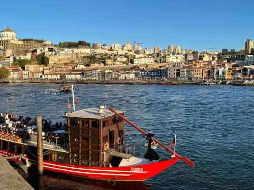 una barca è ormeggiata in acqua vicino a una città di Porto Plage de Matosinhos a Matosinhos