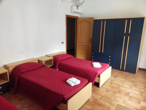 duas camas num quarto com lençóis vermelhos em Residence Europa em Alba Adriatica