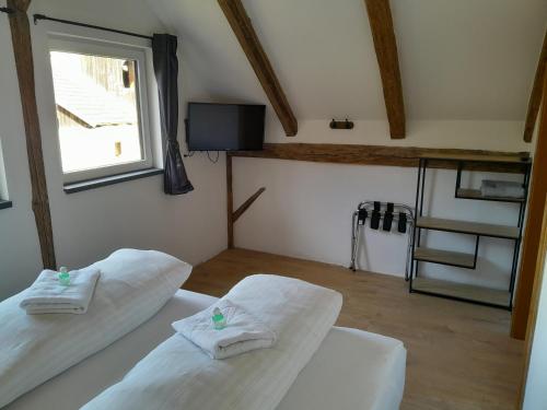 - 2 lits blancs dans une chambre avec fenêtre dans l'établissement Ferienhaus Kolbnitz, à Unterkolbnitz