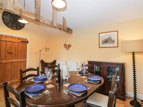 a dining room with a wooden table with blue plates at The DunnitManor Farm in Salisbury