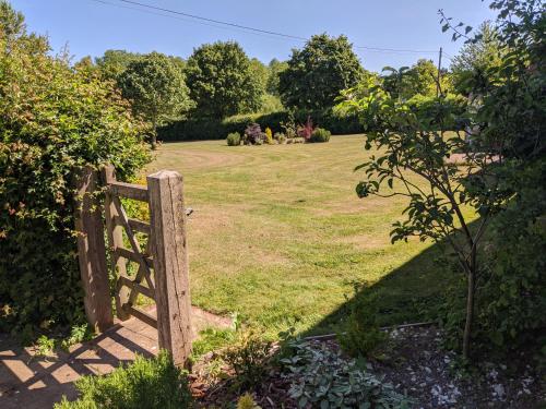a wooden gate in a garden with a field at The DunnitManor Farm in Salisbury