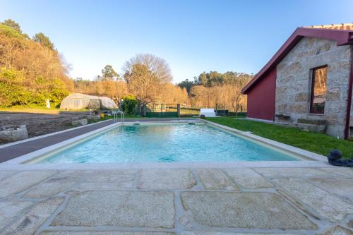 a swimming pool in a yard next to a building at Carvalho Village in Fafe