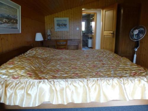 a bedroom with a large bed and a fan at Ferienwohnung Amsoldingen, Berner Oberland, Thunersee Schweiz mit herrlicher Aussicht auf Stockhorn in Amsoldingen