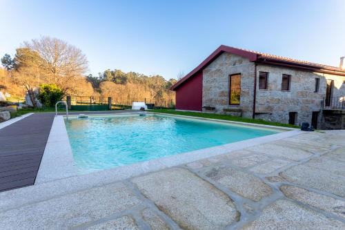 a swimming pool in front of a building at Carvalho Village in Fafe