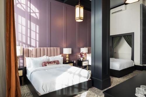 a bedroom with two beds and purple walls at Hotel Thaxter in Portsmouth