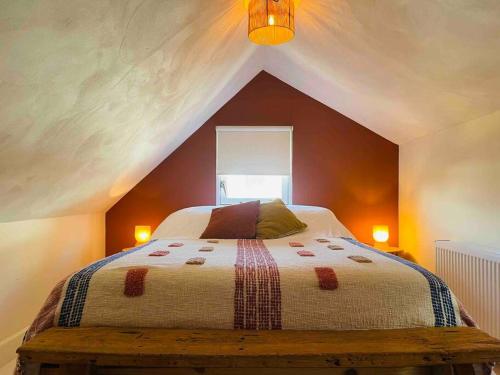 1 dormitorio con 1 cama grande en el ático en The Birdhouse, Tiny home close to the beach en Noordwijk aan Zee