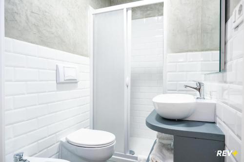 a white bathroom with a toilet and a sink at Lia Art Hotel in La Spezia