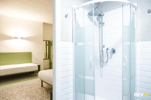 a bathroom with a shower and a bed in a room at Lia Art Hotel in La Spezia
