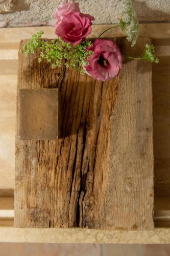 two flowers sitting on top of a piece of wood at Relais Casale Valigi in Narni