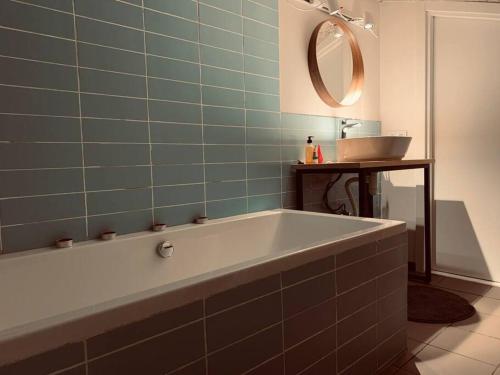 a bath tub in a bathroom with a mirror at Mariam's Stunning and Sunny Apt in Gudauri