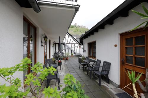 a patio with chairs and tables on a building at Winzerhof Brachtendorf in Alken