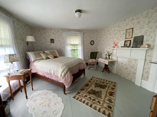 a bedroom with a bed and a fireplace at Sewall House Yoga Retreat in Island Falls