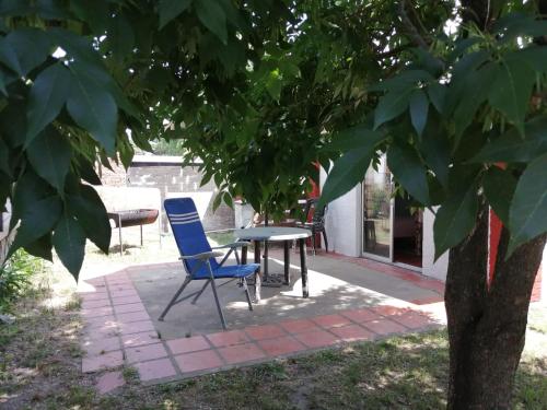 a patio with a table and chairs under a tree at Apartamento 2 ambientes + baño Las Toscas SUR in Las Toscas