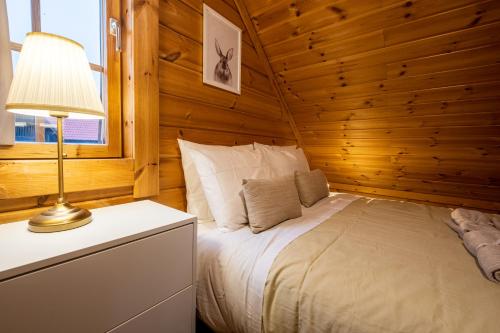 a bedroom with a bed in a log cabin at Chalé de Montanha com sons de rio in Cortes do Meio