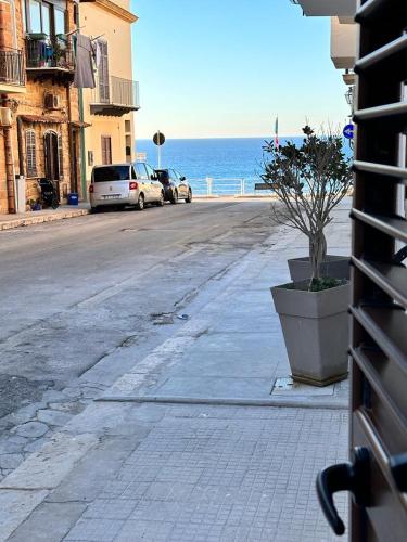 a street with cars parked on the side of the road at I Faraglioni Comfort Rooms in Terrasini