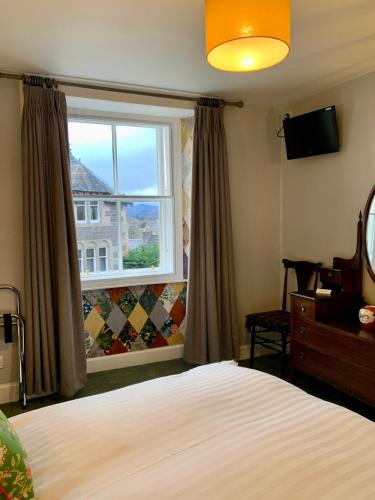 a bedroom with a bed and a window at Squirrel Away At Leven House in Crieff