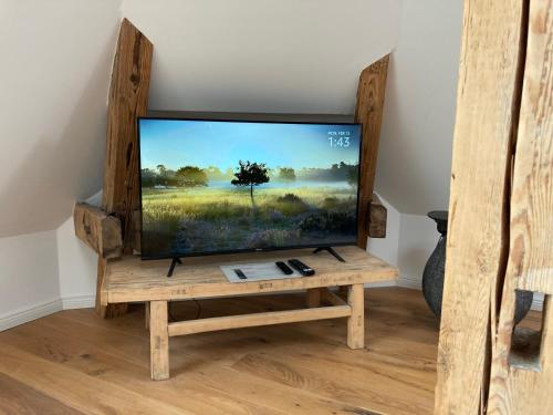 a flat screen tv sitting on a wooden tv stand at RaumAusbeute Design Apartment Hoher Priester in Detmold