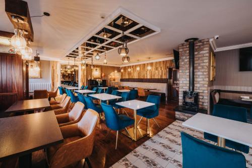 a restaurant with tables and chairs and a fireplace at Bay View Hotel in Kilkee