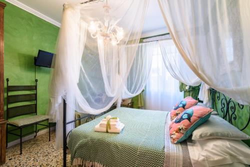 - une chambre avec un lit à baldaquin et des serviettes dans l'établissement BIBI BOUTIQUE AREZZO Appartamento Rosafragola - Verdeconiglio, à Arezzo