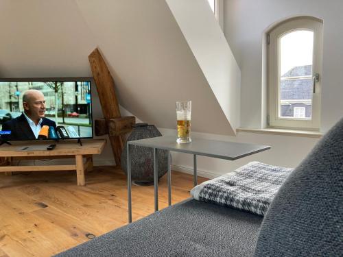 a man sitting at a table with a glass of beer at RaumAusbeute Design Apartment Hoher Priester in Detmold