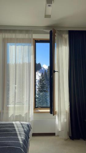 a bedroom with a bed and a large window at Woodside Kopaonik & SPA by Slopeview in Kopaonik