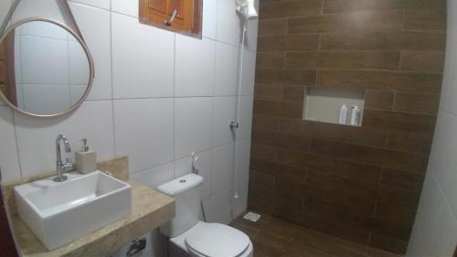 a bathroom with a sink and a toilet and a mirror at Belaninha in Guaramiranga