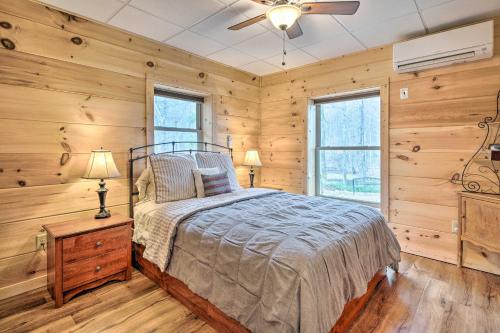 1 dormitorio con paredes de madera, 1 cama y ventilador de techo en Secluded Black Mountain Cabin with On-Site Pond! en Black Mountain