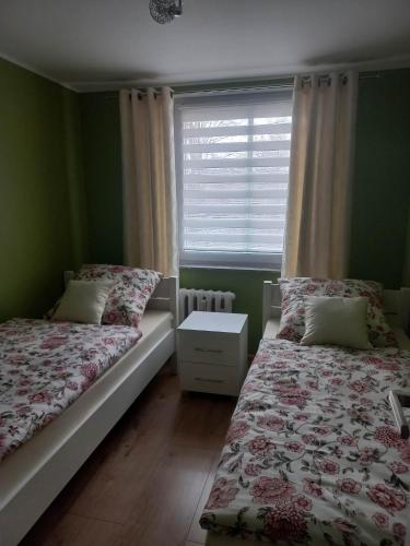 um quarto com 2 camas e uma janela com cortinas em Apartament w centrum Raciborza em Racibórz