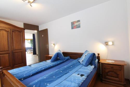 a bedroom with a blue bed with a wooden frame at Casa Yolanda Familienwohnung Mireille in Fieschertal