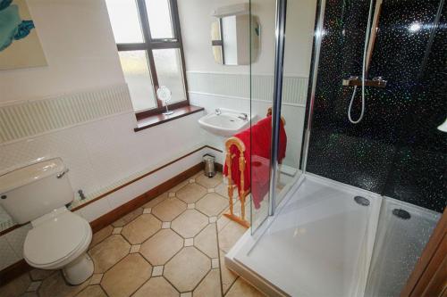 a man standing in a bathroom with a shower at The Drapery, Haltwhistle in Haltwhistle