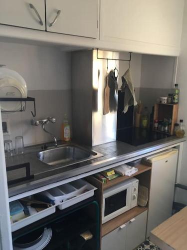 une petite cuisine avec un évier et un micro-ondes dans l'établissement Appartement 300 m plage et port, à Banyuls-sur-Mer