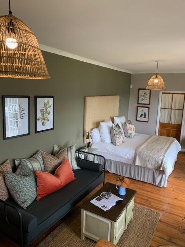 a living room with a bed and a couch at Cheverells Farm, Kiku & Braeburn Cottage in Grabouw