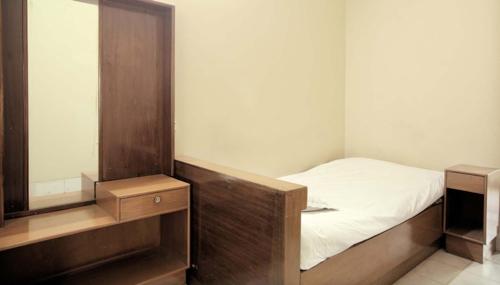 a small bedroom with a bed and a mirror at Hotel Sea Queen in Cox's Bazar