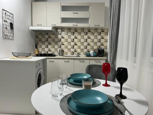 a kitchen with a table with plates and wine glasses at Compact House in Cluj-Napoca