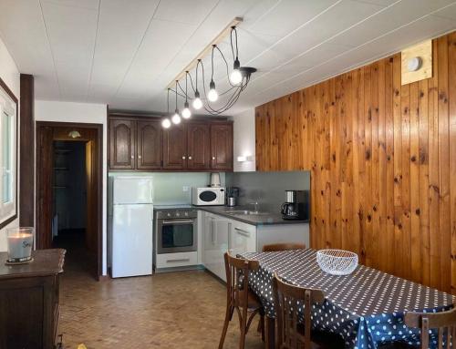 a kitchen with a table and a kitchen with wooden cabinets at Au Coeur du village de Prémanon in Prémanon