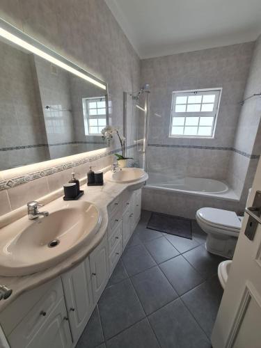 a bathroom with two sinks and a tub and a toilet at Portimão Paradise - Spacious Family Villa in Portimão