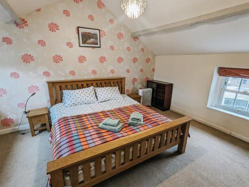 a bedroom with a bed with two towels on it at ELM HOUSE COTTAGE - 2 Bed Cottage in High Hesket on the edge of the Lake District, Cumbria in High Hesket