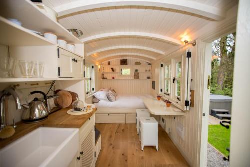 a small kitchen with a bed in a tiny house at The Snug, Netherby, near Carlisle in Longtown