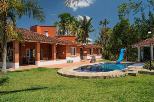 a house with a swimming pool in a yard at Finca El paraíso Guatape in Guatapé