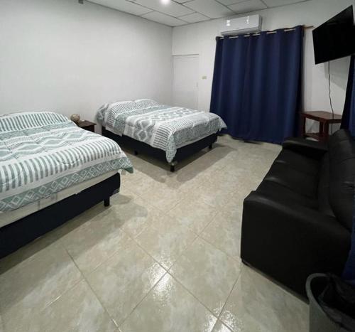 ein Zimmer mit 2 Betten und einem Sofa darin in der Unterkunft Casa Grace in Emiliano Zapata