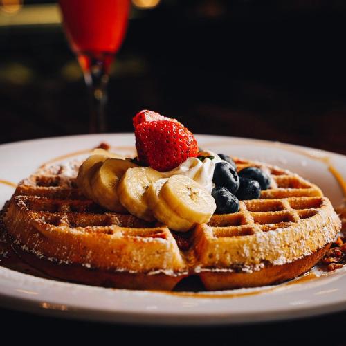 a plate with a waffle with fruit and whipped cream at Ponce Plaza Hotel & Casino in Ponce