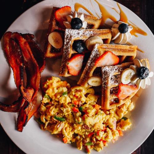 a plate of breakfast food with eggs bacon and toast at Ponce Plaza Hotel & Casino in Ponce