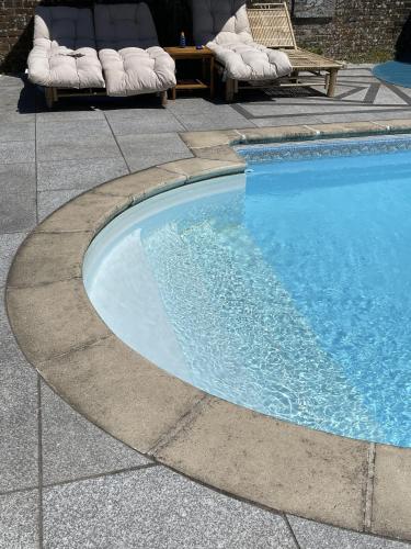a swimming pool in a patio with chairs and a table at Craythornes by Bloom Stays in New Romney