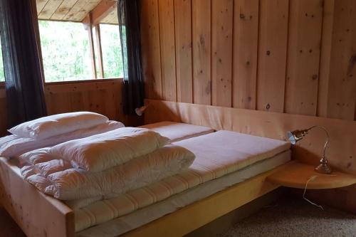 a bed in a wooden room with pillows on it at Olden by the fjords of Norway, Bjørkelund in Stryn