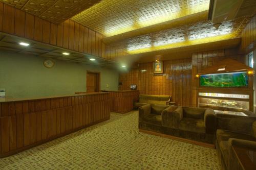 - une salle d'attente avec un canapé et un aquarium dans l'établissement Hotel Sea Queen, à Cox's Bazar