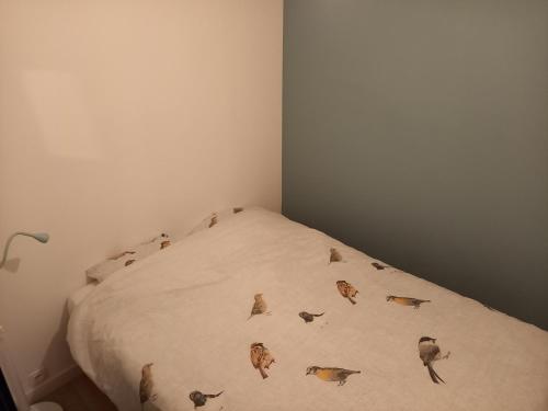 a bedroom with a bed with birds on it at Gite La Volière Ouverte in Valigny
