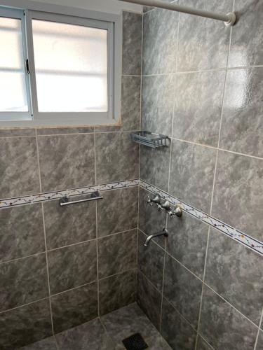 a bathroom with a shower with a window at Dunas Delfin in Monte Hermoso
