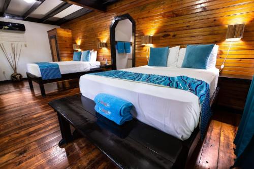 1 dormitorio con 2 camas y espejo en Mango Inn Resort, en Utila