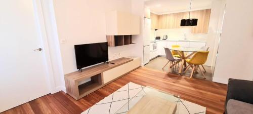 a living room with a television and a kitchen with a table at PISO EN DURANGO in Durango