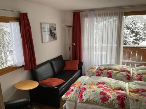 a room with two beds and a couch and a window at Aivla in Celerina